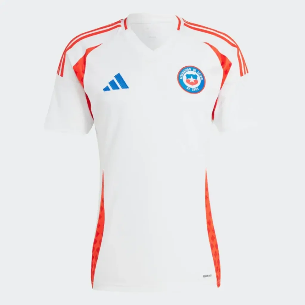 Camiseta de fútbol Adidas de la selección de Chile, blanca con tres franjas rojas en los hombros, paneles laterales rojos con patrón geométrico, el logo azul de Adidas en el pecho derecho y el escudo de la Federación de Fútbol de Chile en el pecho izquierdo.