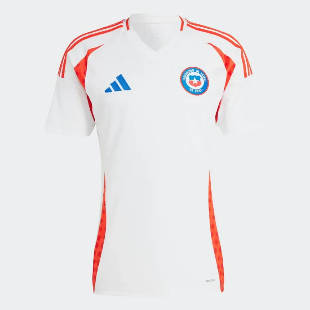 Camiseta de fútbol Adidas de la selección de Chile, blanca con tres franjas rojas en los hombros, paneles laterales rojos con patrón geométrico, el logo azul de Adidas en el pecho derecho y el escudo de la Federación de Fútbol de Chile en el pecho izquierdo.