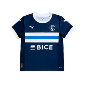 Camiseta de fútbol Puma de Club Deportivo Universidad Católica en azul marino, con cuello y puños blancos. Presenta dos franjas horizontales, una blanca y otra azul claro, en el pecho, junto al logo de Puma, el escudo de la UC y el patrocinador BICE en blanco.