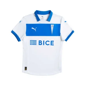 Camiseta de fútbol Puma de local de Universidad Católica, blanca con cuello azul y una franja horizontal azul en el pecho que muestra el logo blanco de Puma y el escudo del club. El patrocinador BICE está impreso en azul debajo de la franja. La camiseta tiene mangas cortas con ribetes azules y tecnología DRYCELL.