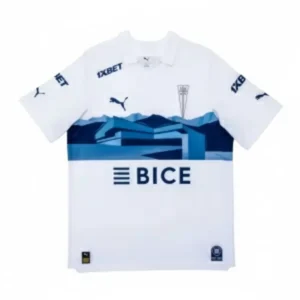 Camiseta de fútbol de local del Club Deportivo Universidad Católica, de color blanco con un diseño de montañas azules en el pecho y los logos de los patrocinadores 1XBET, BICE y Puma.